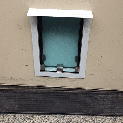 Door model pet door with raincap installed, offering weather protection and secure access